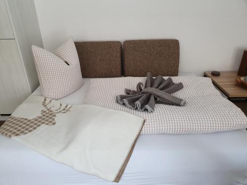 a bed with a blanket and pillows on it at Alpenflair in Berwang