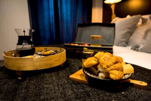 Una mesa con una bandeja de comida sobre una cama. en La Petite Valise, en Ploudalmézeau