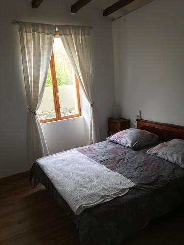 ein Schlafzimmer mit einem Bett und einem Fenster in der Unterkunft Residence Le petit paradis - La petite maison in Labastide-Rouairoux