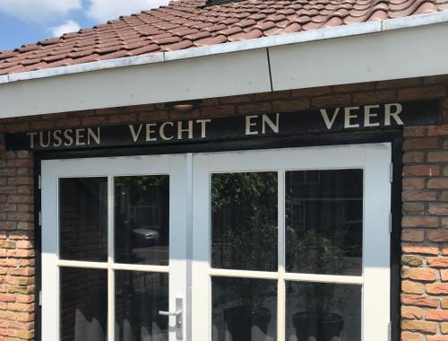 a sign on the front of a building with a door at B&B Tussen Vecht en Veer in Hardenberg