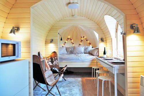 ein Schlafzimmer mit einem Bett und einem Schreibtisch in einem Zimmer in der Unterkunft Les Cocons d'Ardenne - Hébergement insolite in Vaux-sur-Sûre