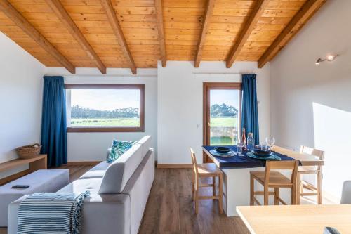 a living room with a couch and a table at LAS RIBERAS. APARTAMENTOS RURALES in Oviñana