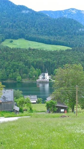 a large white boat on a lake with a house at Haus Schraml in Grundlsee