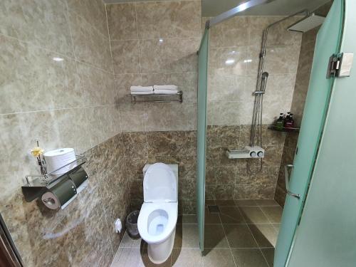 a bathroom with a toilet and a glass shower at Sunrise Hotel Seongsan in Seogwipo