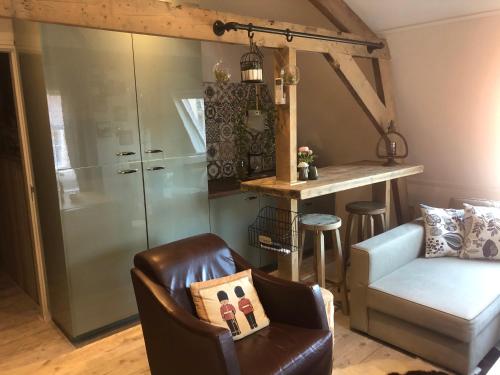 een woonkamer met een bank, een stoel en een aanrecht bij Brasserie de Peperboom in Veere