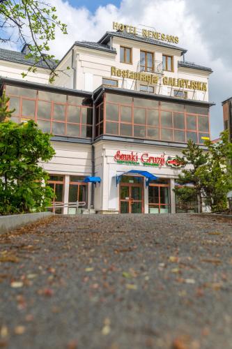 a large white building with a sign on it at Apartamenty Renesans in Krynica Zdrój