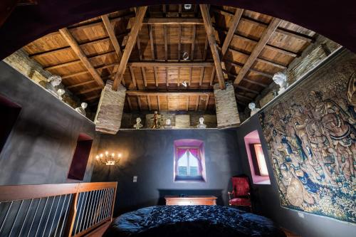 a bedroom with a large bed and a wooden ceiling at Torre Caetani- Night in a medieval tower in Todi