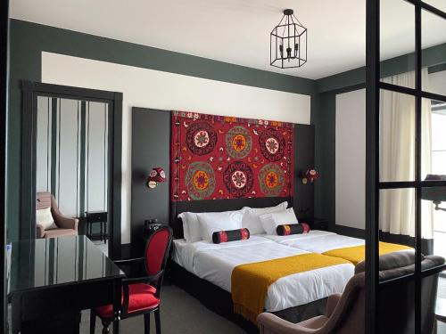 a bedroom with a bed with a red headboard and a table at Esquisse Design Hotel in Tʼelavi