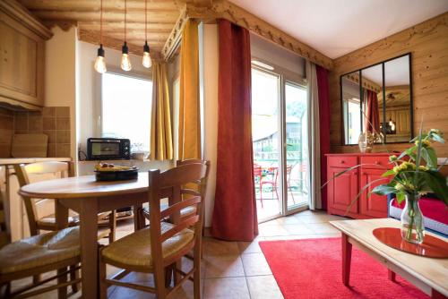 une cuisine et une salle à manger avec une table et des chaises dans l'établissement La Carte Postale, à Duingt