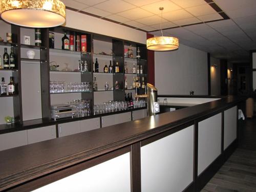 a bar in a restaurant with glasses on the shelves at Hotel Stadt Wittstock in Wittstock