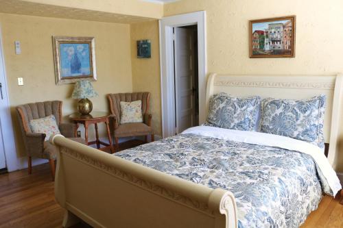 a bedroom with a bed and two chairs at Echo Mountain Inn in Hendersonville