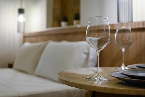 two wine glasses sitting on a table with a bed at Casa D'Irene Deluxe Hotel in Falasarna