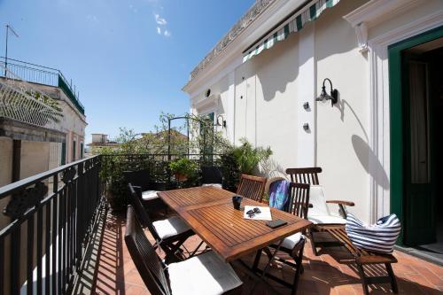 a wooden table and chairs on a balcony at Amalfi Old Square room & apartments , 73 steps from the street in Amalfi
