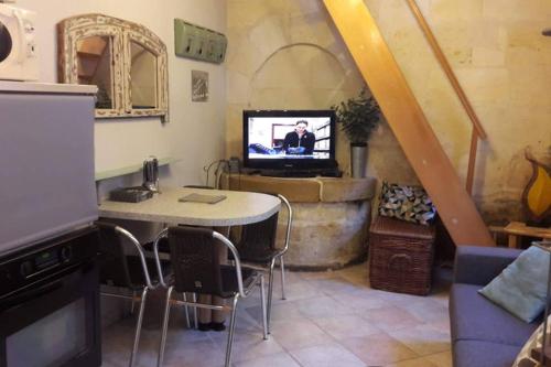 波爾多的住宿－Joli petit loft dans échoppe pierre centre-ville，客厅配有桌子和电视