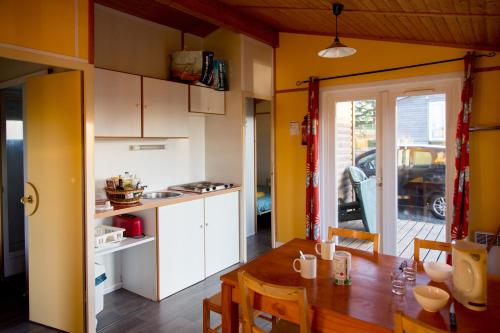 une cuisine et une salle à manger avec une table et des chaises dans l'établissement LES CHALETS D HERMINE, à Montredon-Labessonnié