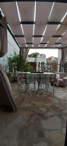 a patio with a table and chairs under a roof at Casa Giampiero in Villaputzu