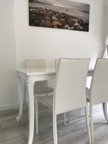 a room with a table and chairs and a painting on the wall at Gioia Bed and Breakfast in Finale Ligure