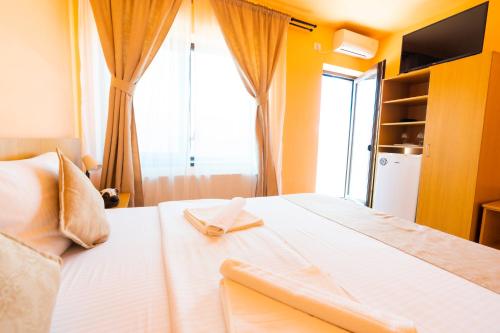 a bedroom with a large white bed with a window at Kys House in Techirghiol