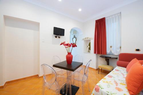 a living room with a table with a vase of flowers on it at Amalfi Old Square room & apartments , 73 steps from the street in Amalfi