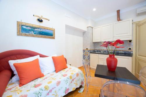 a living room with a red vase with flowers on a table at Amalfi Old Square room & apartments , 73 steps from the street in Amalfi