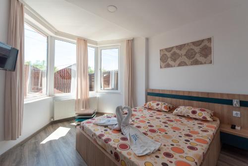 a bedroom with a bed with a towel on it at Vila Jun in Eforie Nord