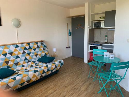 ein Wohnzimmer mit einem Sofa und einem Tisch sowie eine Küche in der Unterkunft Studio 203 - Greoux in Gréoux-les-Bains