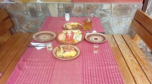 a table with a pink table cloth with food on it at Kod Dace in Banja Topilo