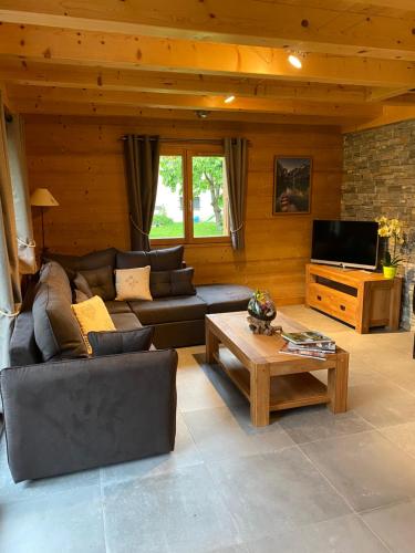 uma sala de estar com um sofá e uma mesa de centro em Chalet luxe L'HIBISCUS em Samoëns