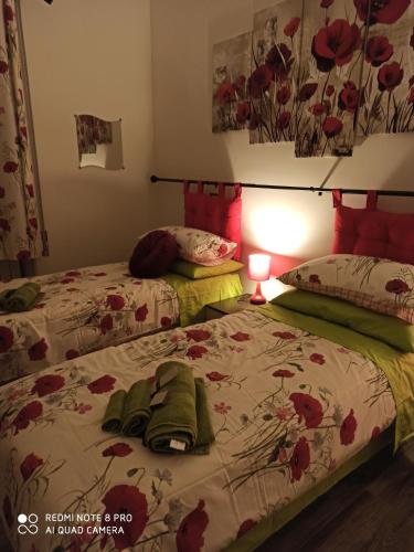 two twin beds in a bedroom with a lamp at Affittacamere da Barby in Rome