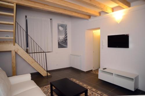 a living room with a staircase and a tv at B&B Thule in Caltanissetta