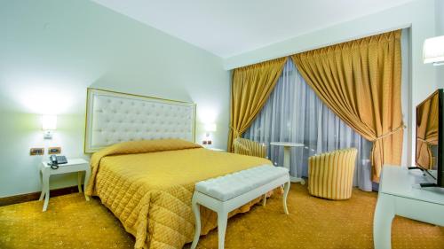 une chambre d'hôtel avec un lit et une télévision dans l'établissement Hotel Fieri, à Fier