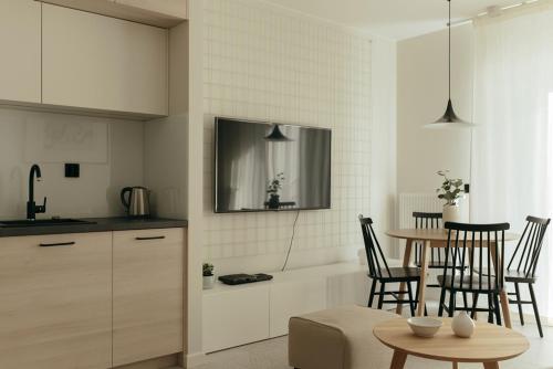 a kitchen and dining room with a table and chairs at APARTAMENT Marina Port in Wrocław