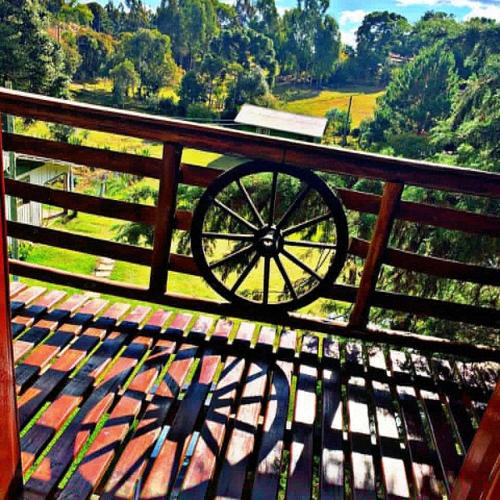 a wagon wheel sitting on top of a wooden fence at CHALÉ ESTÂNCIA OURO VERDE in Lages