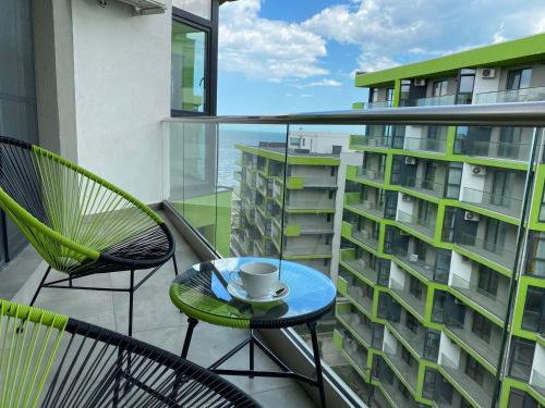 a balcony with a cup of coffee on a table at Deko Apartments Alezzi Beach Mamaia in Mamaia Nord