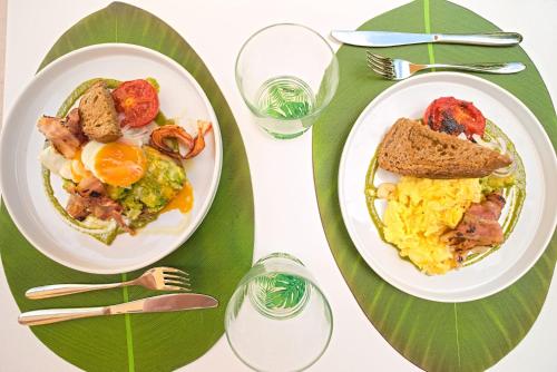 two plates of breakfast food on a table with forks at B&B CASA GIOVANNA in Campese