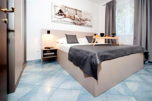 een slaapkamer met een bed en een tafel op een tegelvloer bij F&R Apartments II in Rovinj