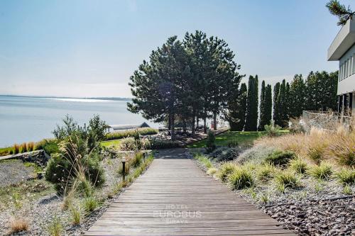 a wooden path next to a house and the water at Hotel Eurobus in Kaluža