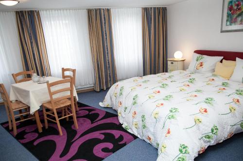 Hotel Gästehaus Priester في ليمبورغ ان دير لان: غرفة نوم بسرير وطاولة وكراسي