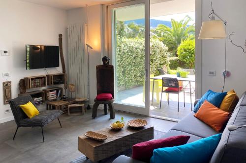 a living room with a couch and a tv and a patio at Pietraverdemare in Vallebona