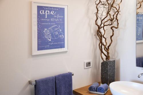 a bathroom with a sink and a vase with a tree at Pietraverdemare in Vallebona