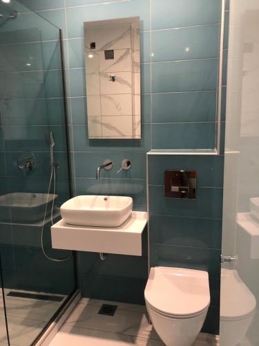 a bathroom with a sink and a toilet and a mirror at Margarita's Rooms in Potos