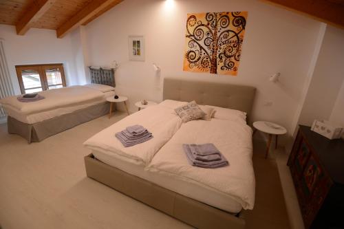 a bedroom with two beds and a painting on the wall at Casa di Patrizia in Calavino