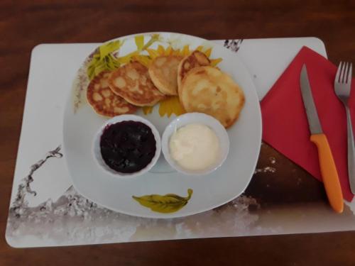 a plate of breakfast food with a face on it at Hotel Le Commerce in Neuville