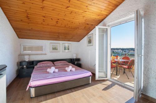 1 dormitorio con 1 cama y balcón con mesa en Horizont view apartment en Pula