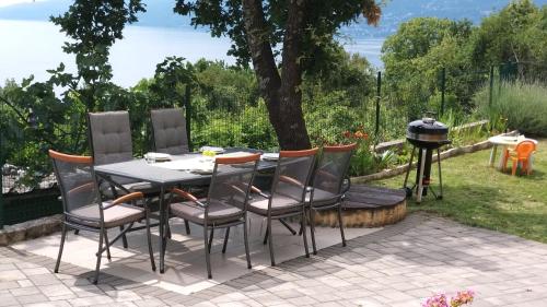 a table and chairs on a patio with a grill at Apartments Turan in Rijeka