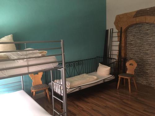 Zimmer mit 2 Etagenbetten und 2 Stühlen in der Unterkunft WOHNUNG IN KAISERSLAUTERN in Kaiserslautern