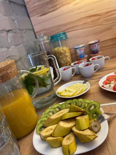 a table with plates of food and a plate of fruit at Kamienica Morska Gdynia in Gdynia