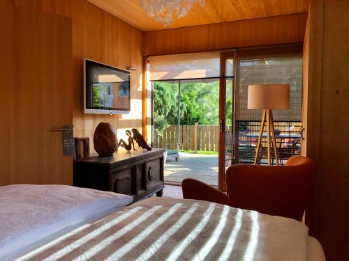 安尼海姆的住宿－My Tiny Moos - Exklusiver Urlaub im Tiny House，卧室配有床、椅子和窗户。