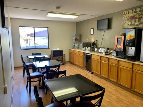 a dining room with tables and chairs and a kitchen at Econo Inn in Columbus