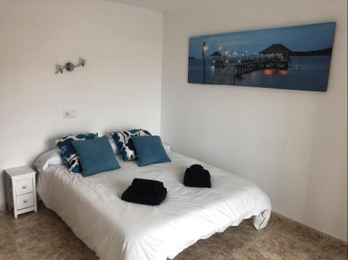 a bedroom with a white bed with blue pillows at Beta's place - Apartamento primera línea de playa in Blanes